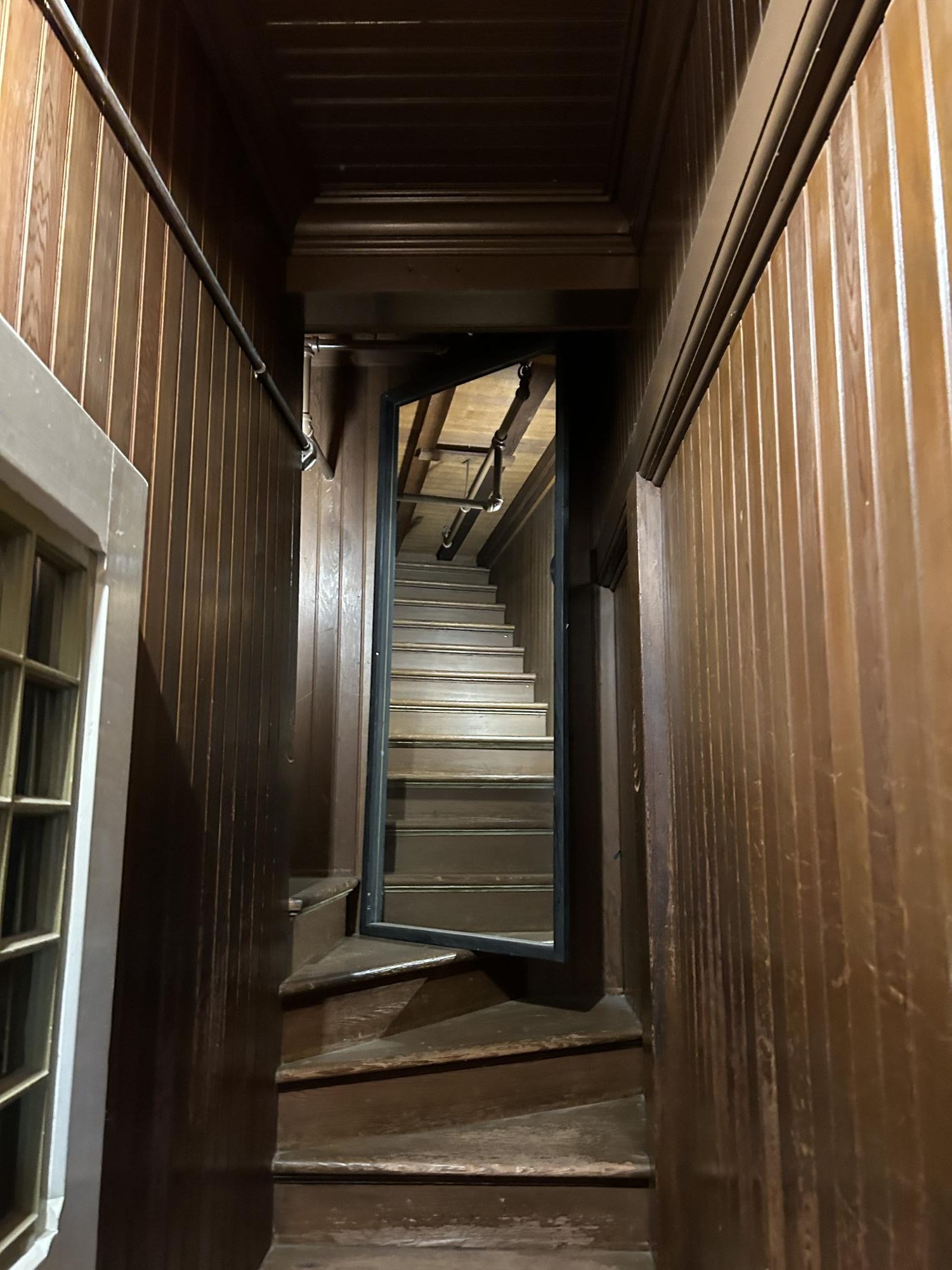 An eerie staircase leading to nowhere within the Winchester Mystery House, symbolizing its architectural oddities.