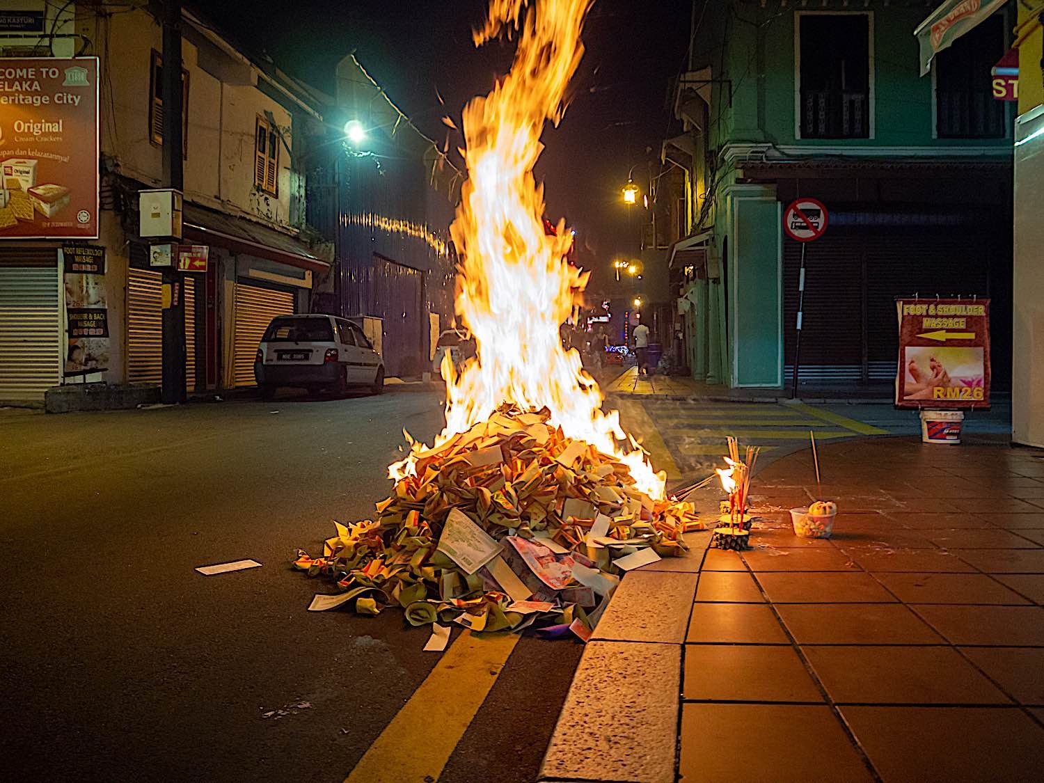 Ceremonial burning of paper money to honor ancestors during the Hungry Ghost Festival.