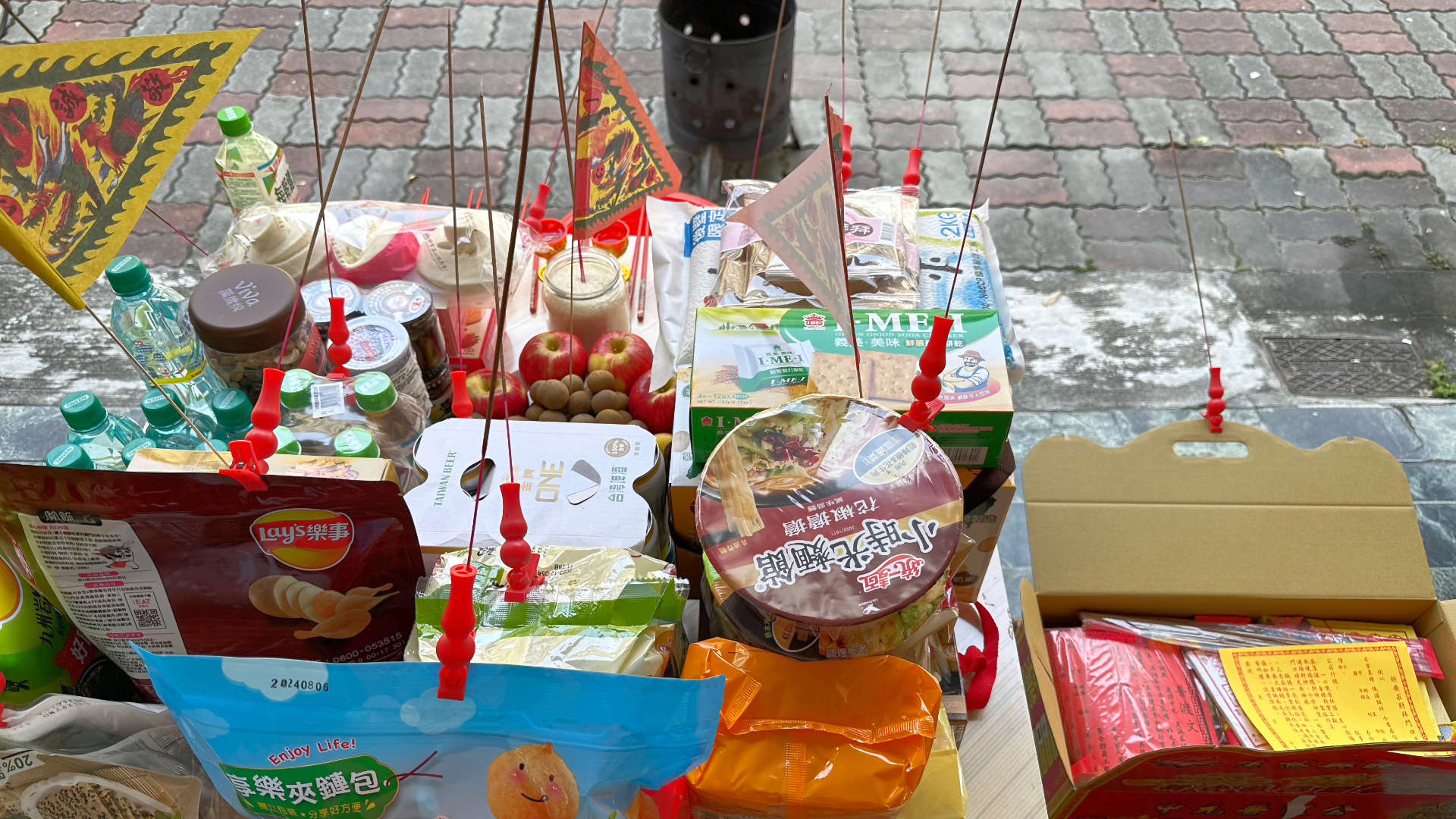 Food offerings and joss paper burners prepared outside a Taiwanese family home during Ghost Month.