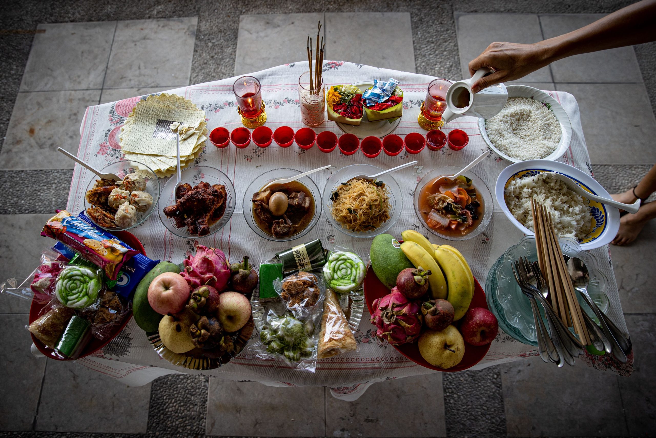 Preparation of food offerings for the Hungry Ghost Festival, depicting community efforts in honoring ancestors.